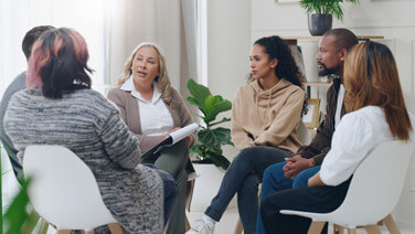 Counseling, group and psychology discussion with group of diversity people in therapy for depression, stress and anxiety. Men and women healing during psychologist meeting talking about mental health.