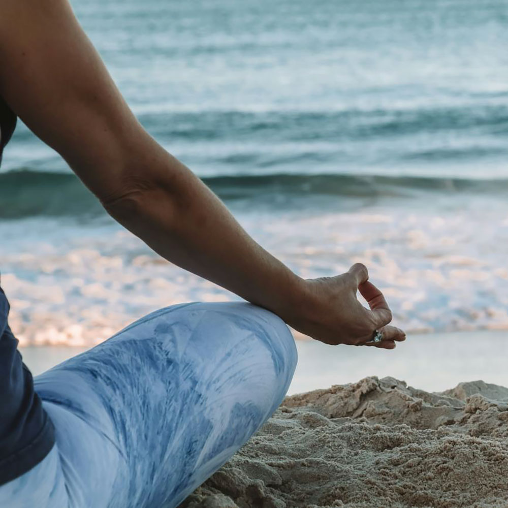 person meditating on the beach